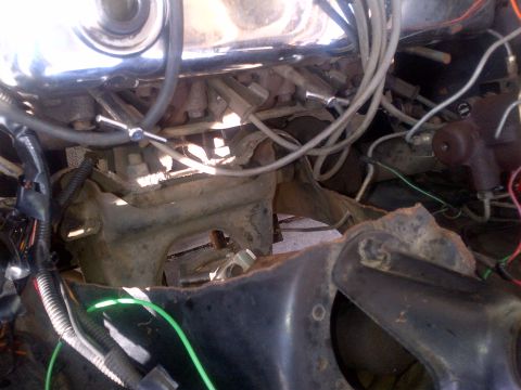1965 Ford Mustang - Engine bay components, including wiring and engine block parts, are shown in this close-up.