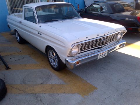 1965 Ford Mustang - This 1960 Ford Falcon Ranchero pickup truck is white with chrome wheels and is parked on concrete.