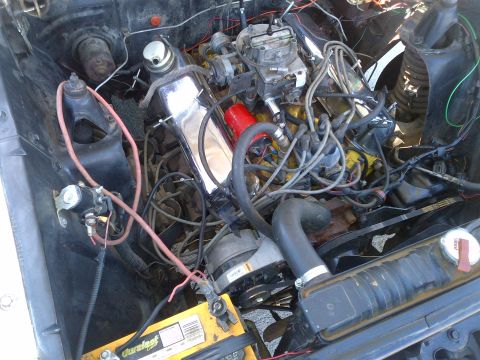 1965 Ford Mustang - A close-up view of a car's engine compartment, showing the engine, battery, and various components.