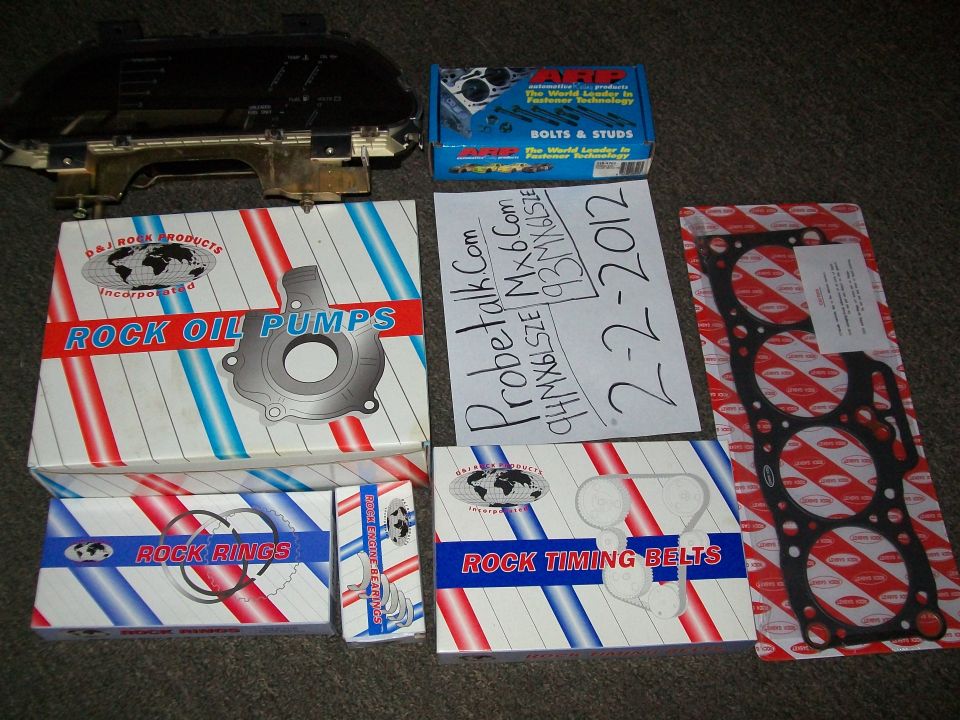 Car parts including oil pump, timing belts, and gasket, with a dashboard