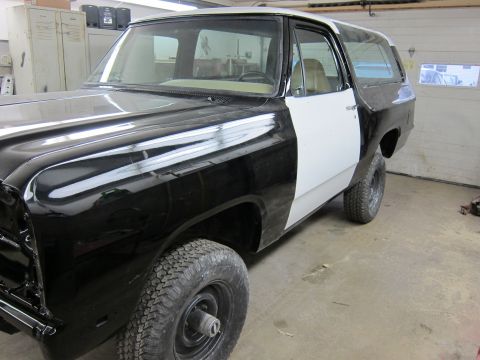 1987 Dodge 1500 - This two-tone SUV is in a garage, showing off its black front and white rear body panels.