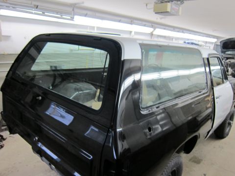 1987 Dodge 1500 - This black and white SUV is undergoing bodywork in a garage. The registry claims it is a 1987 Dodge 1500.