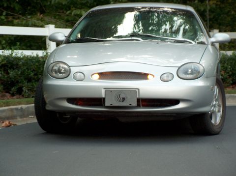1998 Ford Taurus - Front view of a silver sedan with its headlights on.