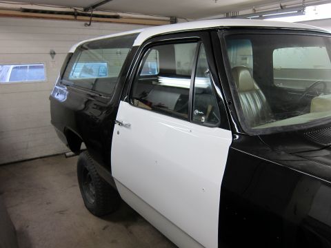 1987 Dodge 1500 - This two-tone SUV is parked inside a garage, possibly undergoing repairs or a paint job.