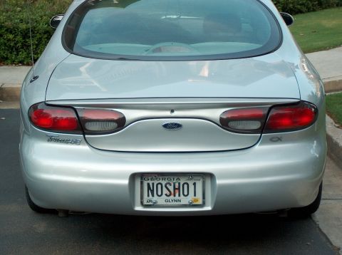 1998 Ford Taurus - This silver 1998 Ford Taurus is viewed from the rear, displaying its taillights and license plate.
