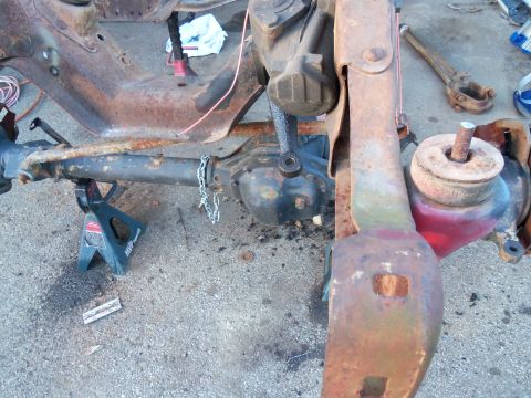 1987 Ford Ranger - Close-up view of heavily rusted truck frame and suspension components supported by jack stands.
