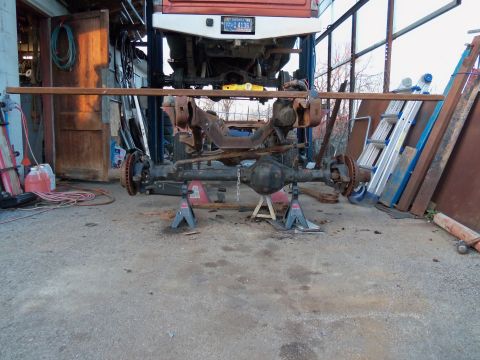 1987 Ford Ranger - Vehicle's front axle assembly is supported by jack stands in a garage setting.