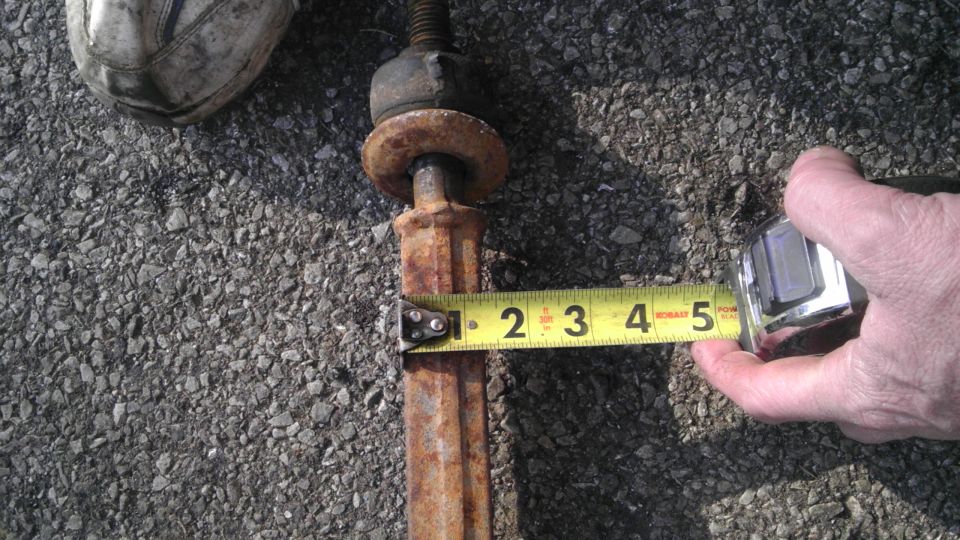 Rusty metal rod with a tape measure showing approximately 2.5 inches