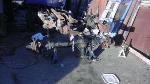 1987 Ford Ranger - The chassis of a truck is shown on jack stands with the front and rear axles removed for repair or modification.