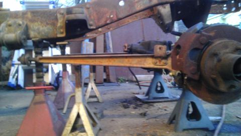 1987 Ford Ranger - Vehicle frame and suspension parts are rusted and supported by multiple jack stands.