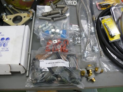 1976 Chevrolet Corvette - Various automotive parts are laid out, including a bushing kit and suspension components.