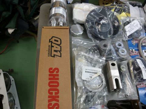 1976 Chevrolet Corvette - Various automotive parts, including shocks and other components, are laid out on a table.