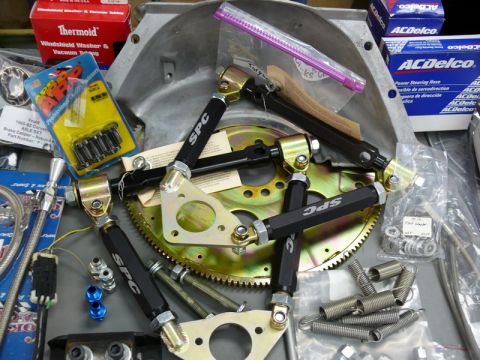 1976 Chevrolet Corvette - Various automotive parts are laid out, including suspension components and engine parts.