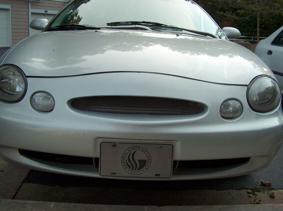 Silver sedan front view, showing grille and license plate