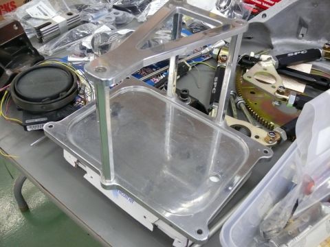 1976 Chevrolet Corvette - An aluminum bracket kit is displayed on a table alongside various automotive parts.