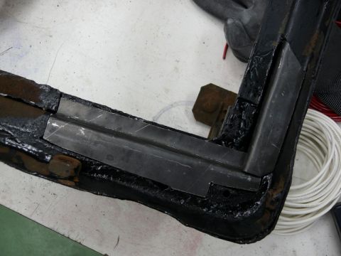 1976 Chevrolet Corvette - Close-up of a reinforced car frame corner, showing added metal plates and protective coating.