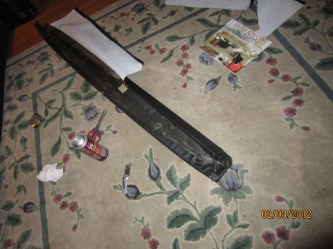 1979 Ford Bronco - An interior trim piece lies on a carpeted floor next to tools and a can of spray paint.