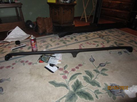 1979 Ford Bronco - A car part is laid out on a rug, with a spray can and remote nearby.