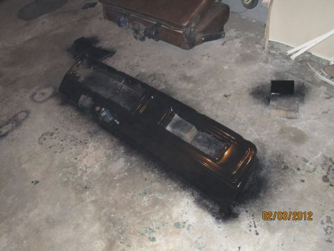 1979 Ford Bronco - A black dashboard assembly is shown on a concrete floor with spray paint cans in the background.