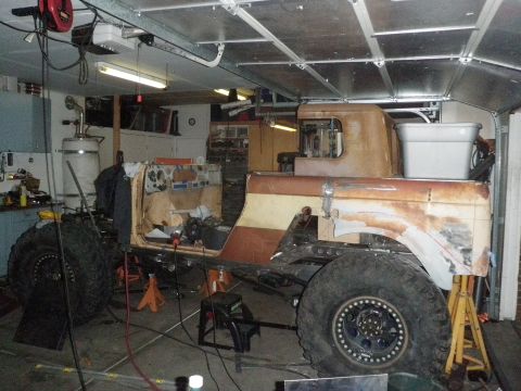 1961 International Scout 800 - This heavily modified vehicle, possibly a custom build or restoration project, is shown in a garage setting with its body and frame exposed.
