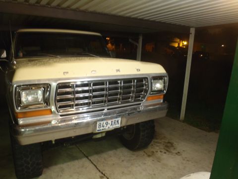 1979 Ford Bronco - This Ford truck, likely from the late 1970s, is parked under a carport with its front grille and headlights visible.