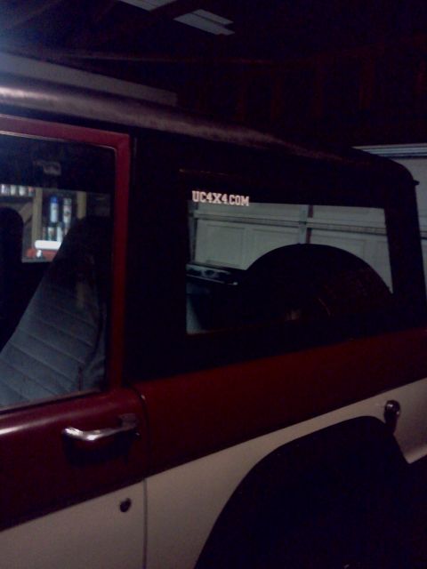 1968 Ford Bronco - A red and white SUV is parked indoors, a sticker on the rear window that reads UC4X4.COM.