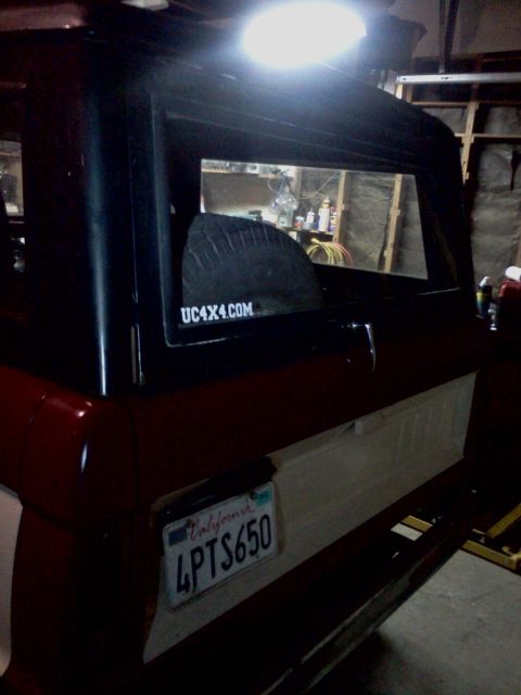 1968 Ford Bronco - Rear interior view of a 1968 Ford Bronco, a spare tire and a website sticker.