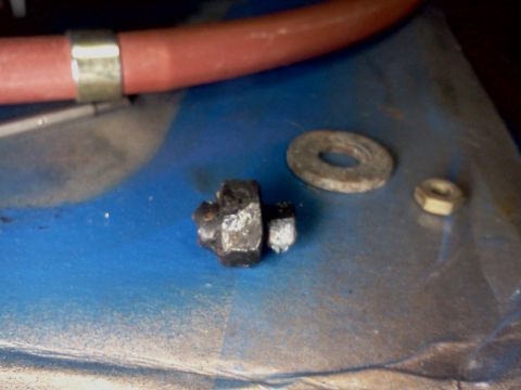 1968 Ford Bronco - Close-up of a bolt, washer, and nut, likely automotive parts.