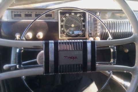 1991 Ford Crown Victoria - The interior of a classic vehicle features a prominent steering wheel and a dashboard with a central speedometer and other gauges.