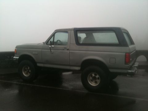 1988 Ford Bronco - This SUV, likely a 1987 model, is seen from the side on a foggy day.