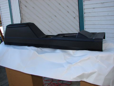 1973 Ford Ranchero - A black center console part is shown from the side, resting on white paper.