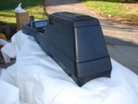 1973 Ford Ranchero - Center console part, possibly from a car, resting on white fabric outdoors.