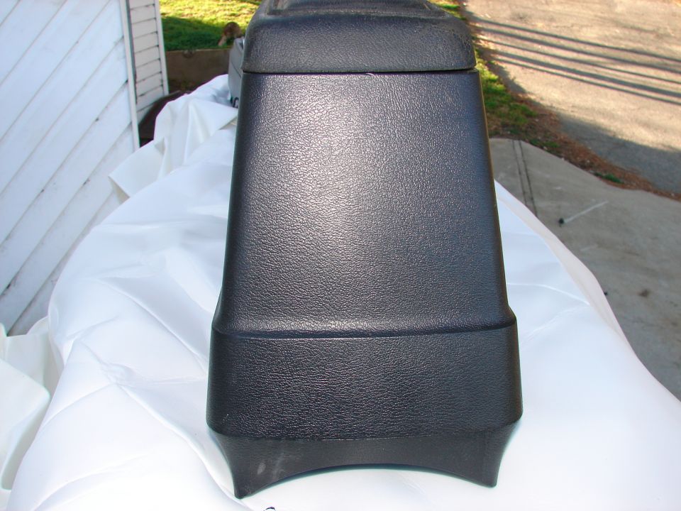 Black plastic automotive center console with textured surface
