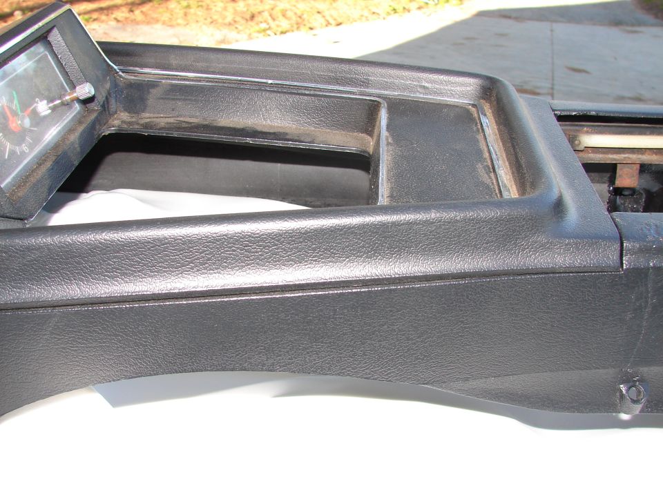 Dashboard trim piece with a gauge inset. The gauge has red and green markings