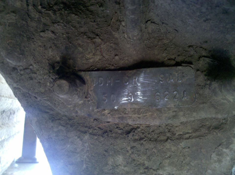 VIN plate with numbers 50-91-622A attached to dirty undercarriage