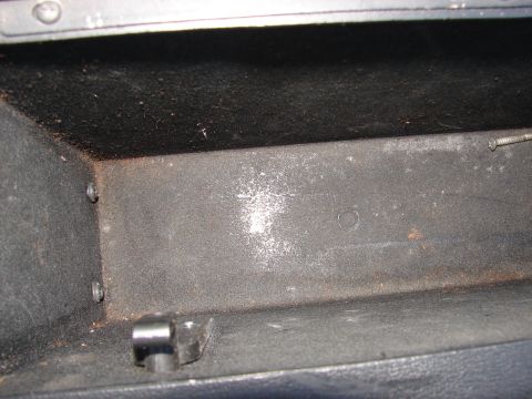 1973 Ford Ranchero - The interior of a vehicle's glove box is shown, appearing dusty and empty with some visible hardware.