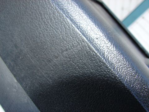 1973 Ford Ranchero - Detail of a black textured plastic component, showing surface wear and scratches.