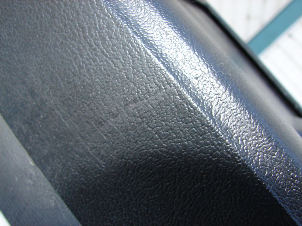 Close-up of black textured plastic with visible scratches