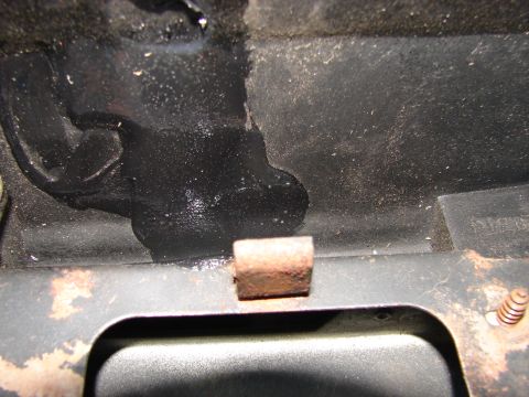 1973 Ford Ranchero - Detail shot of a vehicle's engine bay, showing a small metal bracket and dark, possibly greasy, surfaces.