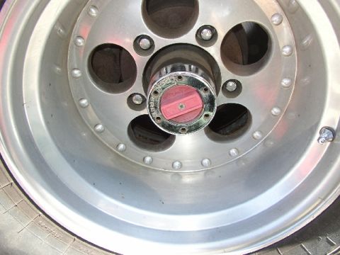 1989 Ford Bronco - Wheel hub assembly with a red locking mechanism, part of a vehicle's wheel.