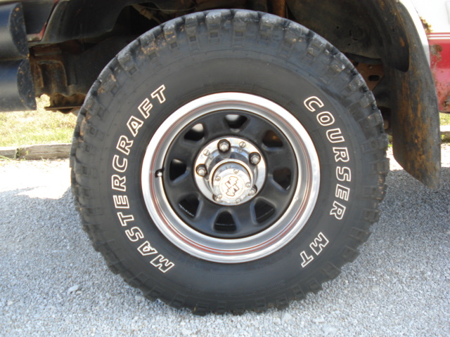 Tire with Mastercraft Courser MT text on a black wheel with red trim