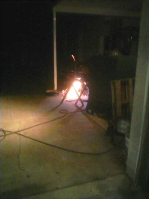 1982 Ford F-100 - Welding sparks illuminate a dark garage space, with cables running across the concrete floor.