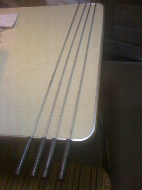 1968 Ford Mustang - Four metal rods, possibly for grilling or a similar purpose, are laid out on a table surface.