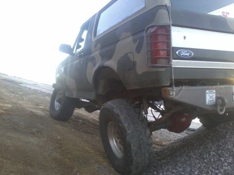 1995 Ford Bronco - This lifted Ford Bronco is shown from the rear, equipped with off-road tires and camouflage paint.