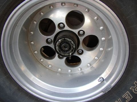 1989 Ford Bronco - Close-up of a wheel hub assembly, showing lug nuts and part of the tire.