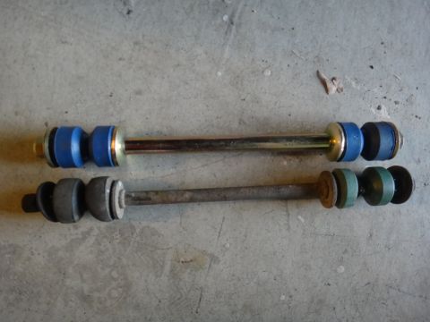 1993 Ford Taurus - Comparison of a new sway bar link with blue bushings and an old sway bar link with green and gray bushings.