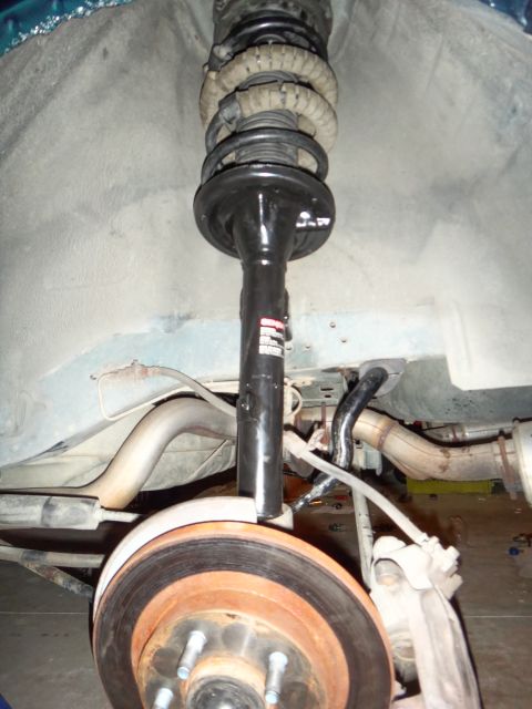 1993 Ford Taurus - The rear suspension and brake components of a vehicle are visible in this close-up shot.