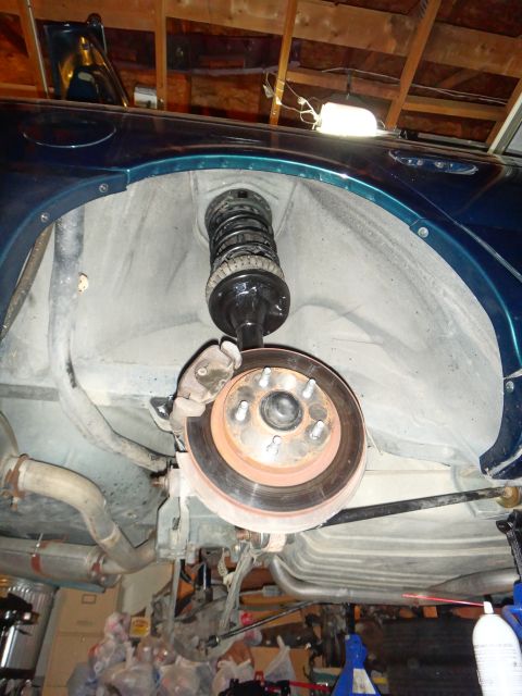 1993 Ford Taurus - The rear suspension and brake components of a 1993 Ford Taurus are visible from below.