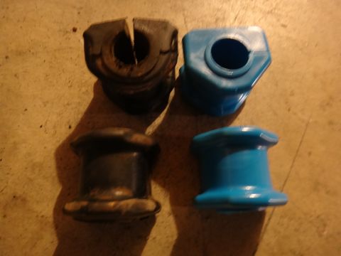 1993 Ford Taurus - Comparison of old and new suspension bushings, one set black and worn, the other blue and new.