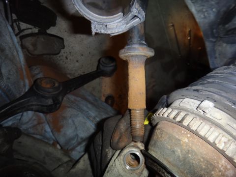 1993 Ford Taurus - Close-up of a rusty suspension bolt and surrounding automotive parts.